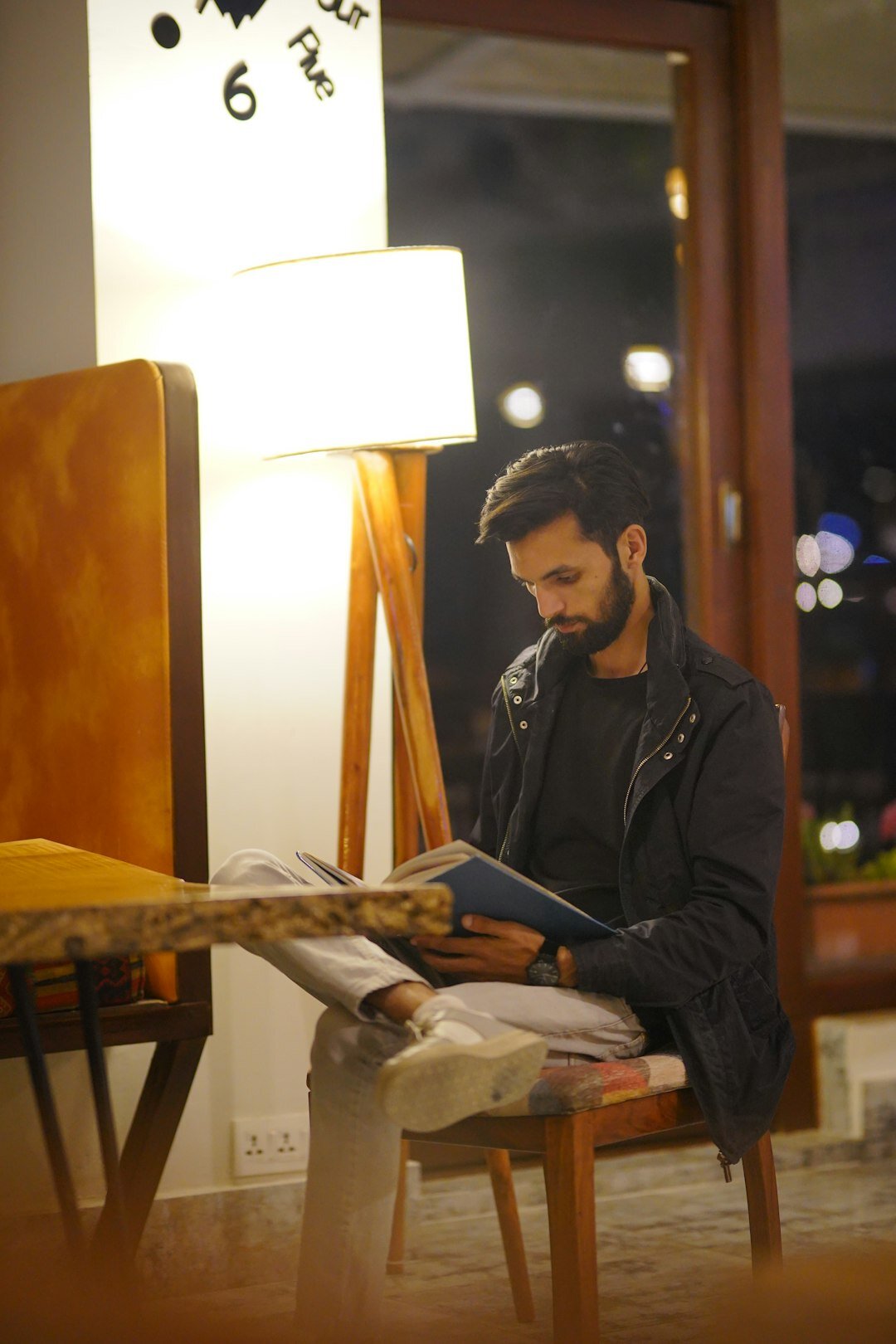 man reading book in cafe